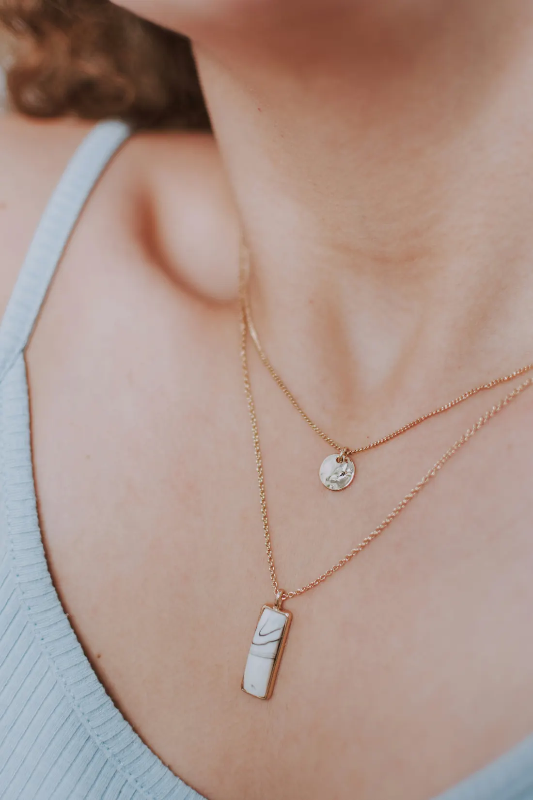 Close-up of two layered gold necklaces